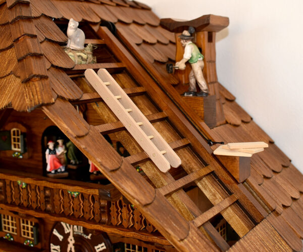 Dachdeckeruhr zeigt als Motiv ein Dachdecker auf einem Schindeldach und einer Katze auf dem Heuboden